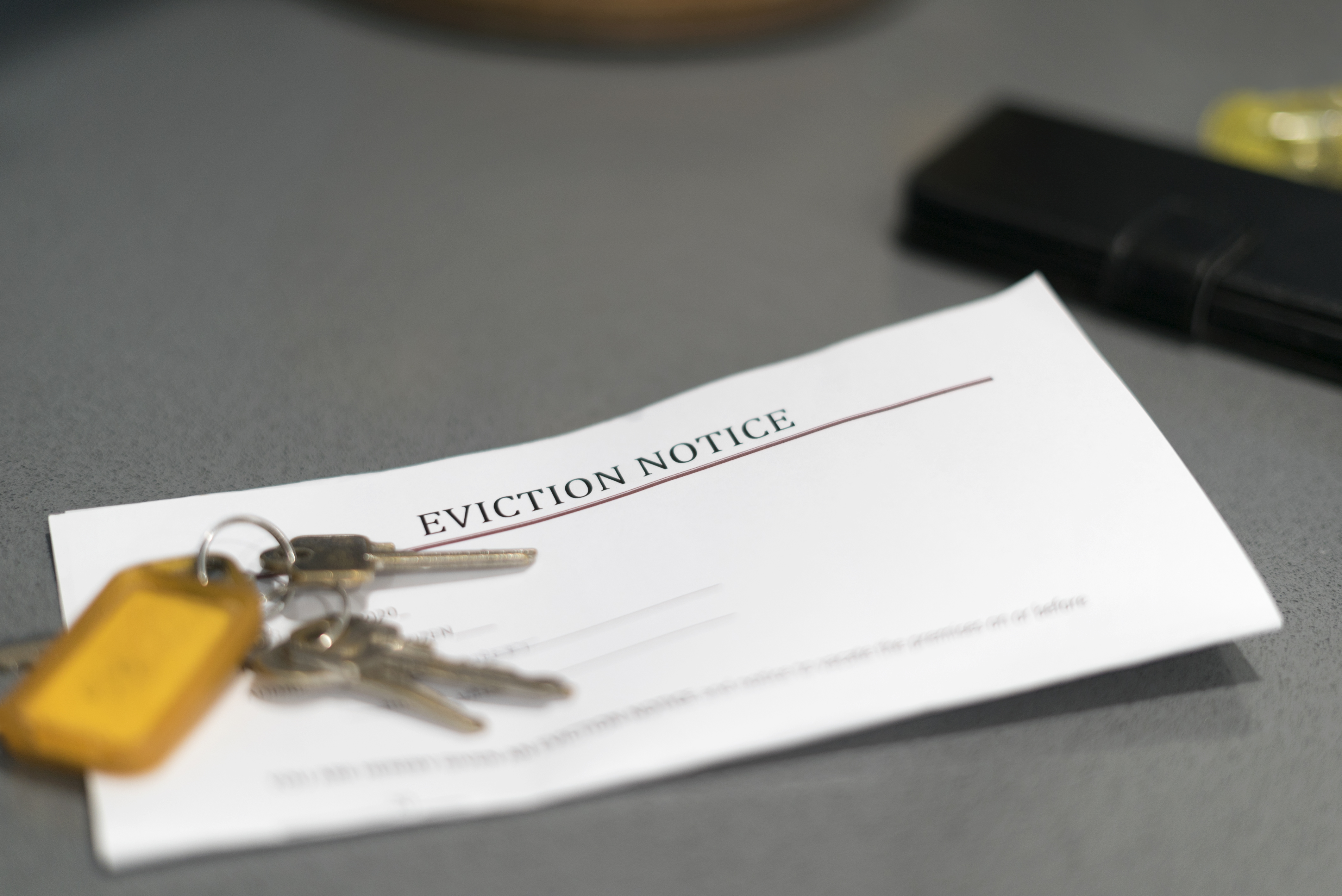 an eviction notice and house keys on table