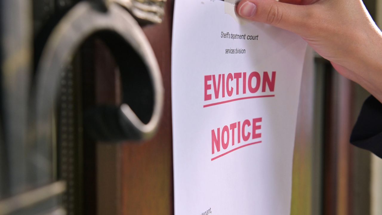person placing an eviction notice on a door