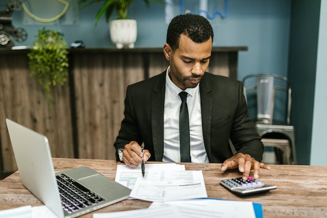 an accountant looking over documents while using a calculator